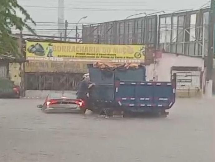 Carro fica submerso em rua alagada e motorista &eacute; resgatado por caminhoneiro em Macei&oacute;